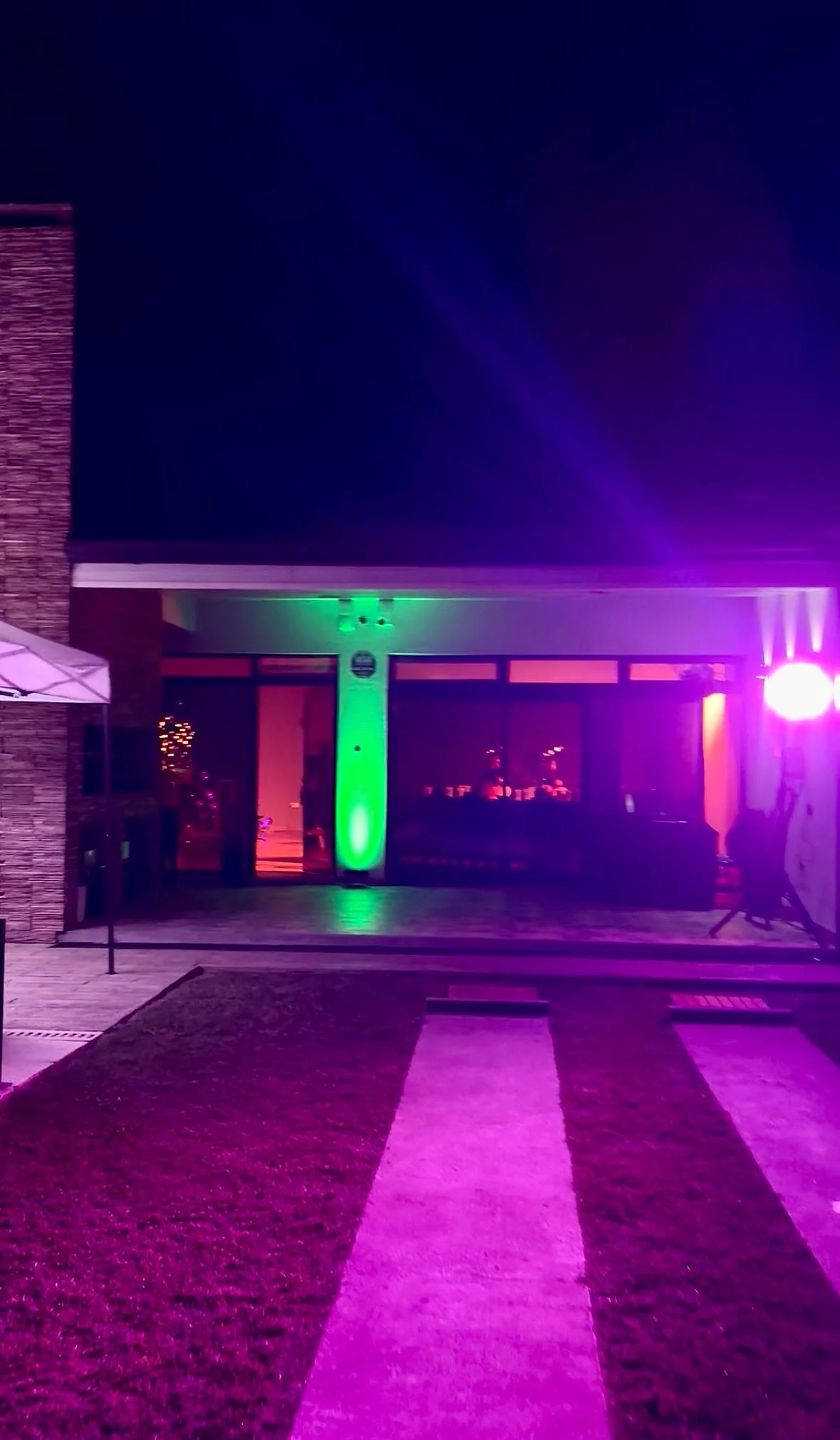 Entrada de un salón iluminada en magenta y verde